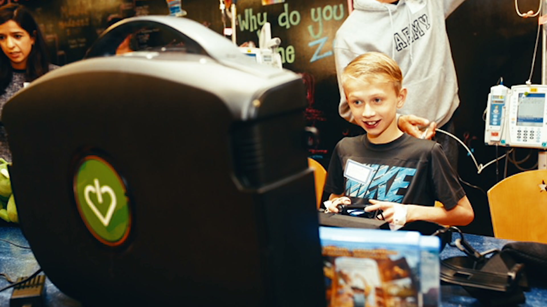 A boy smiling at a GameChanger gaming station in a hospital playroom.