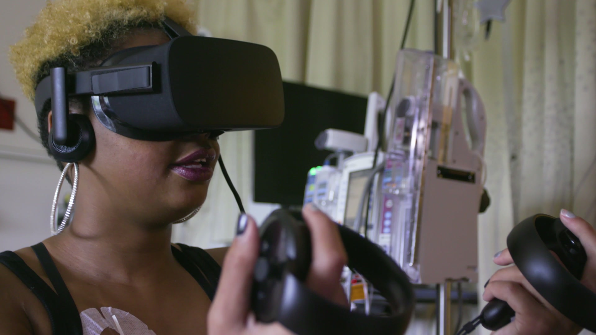 A teen patient using a VR headset and controllers in their hospital room.